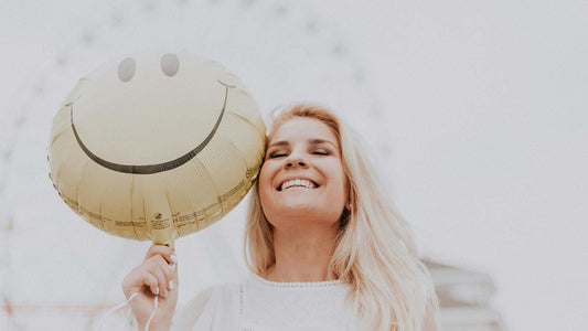 woman holding a smiley balloon