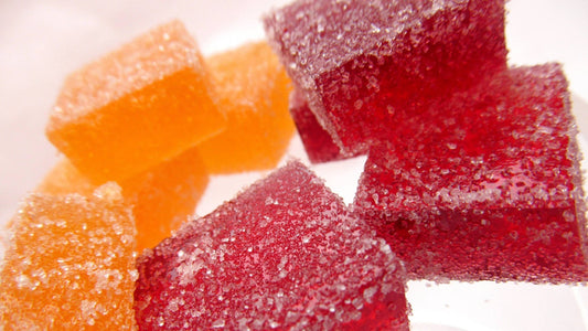 Sweet square-shaped gummies in red and orange colors.