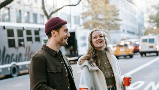 couple walking on street with coffee cups