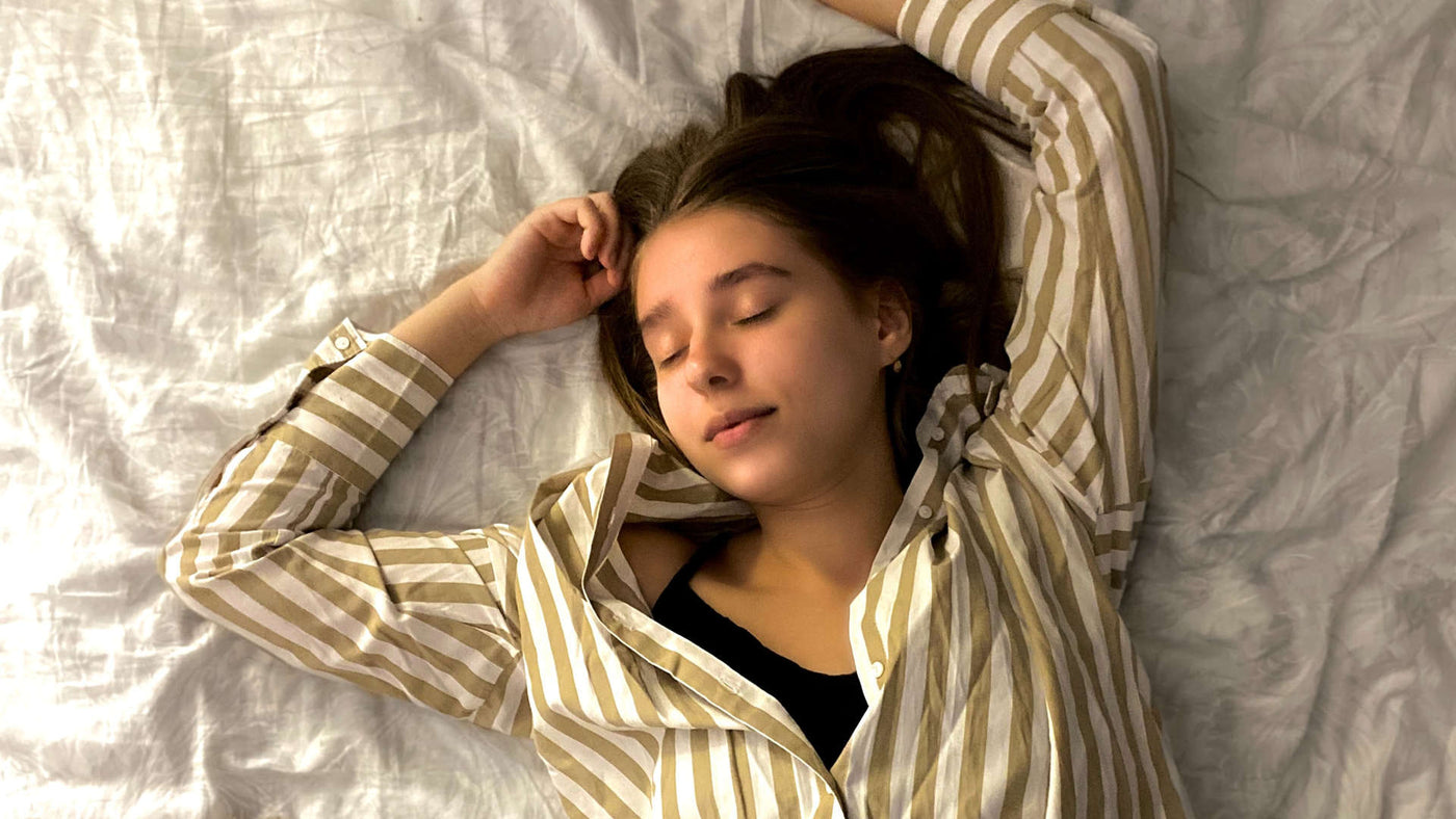 woman in striped long sleeve shirt sleeping on bed