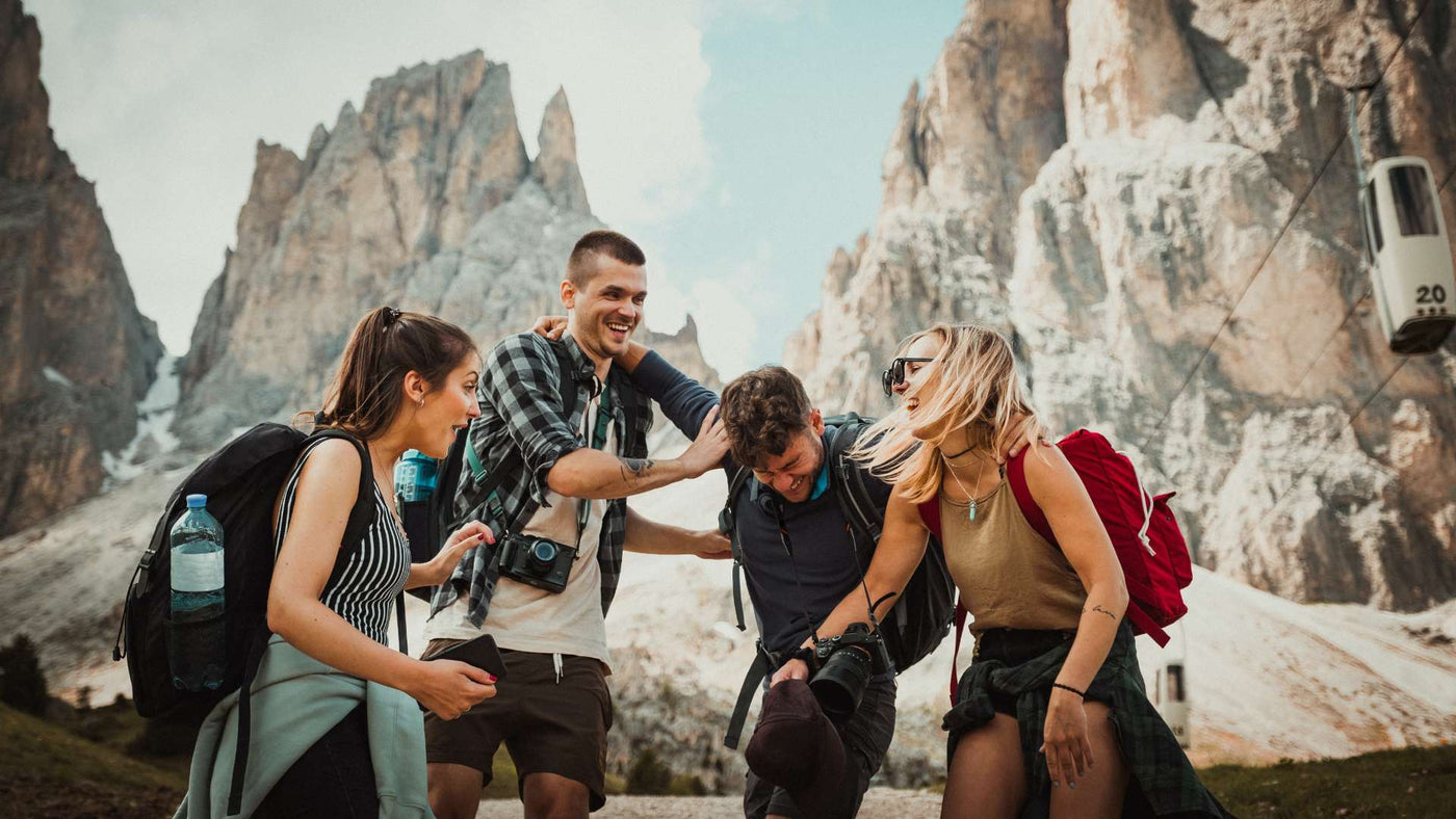Four friends with backpacks enjoying themselves in the mountains