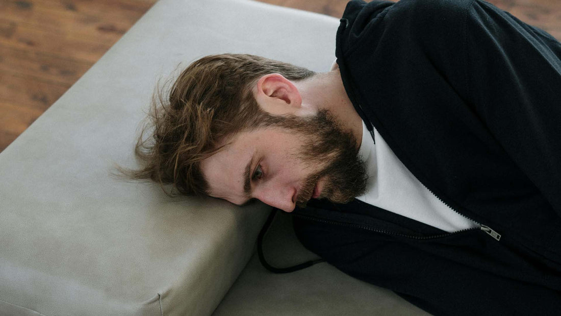 man lying on gray couch