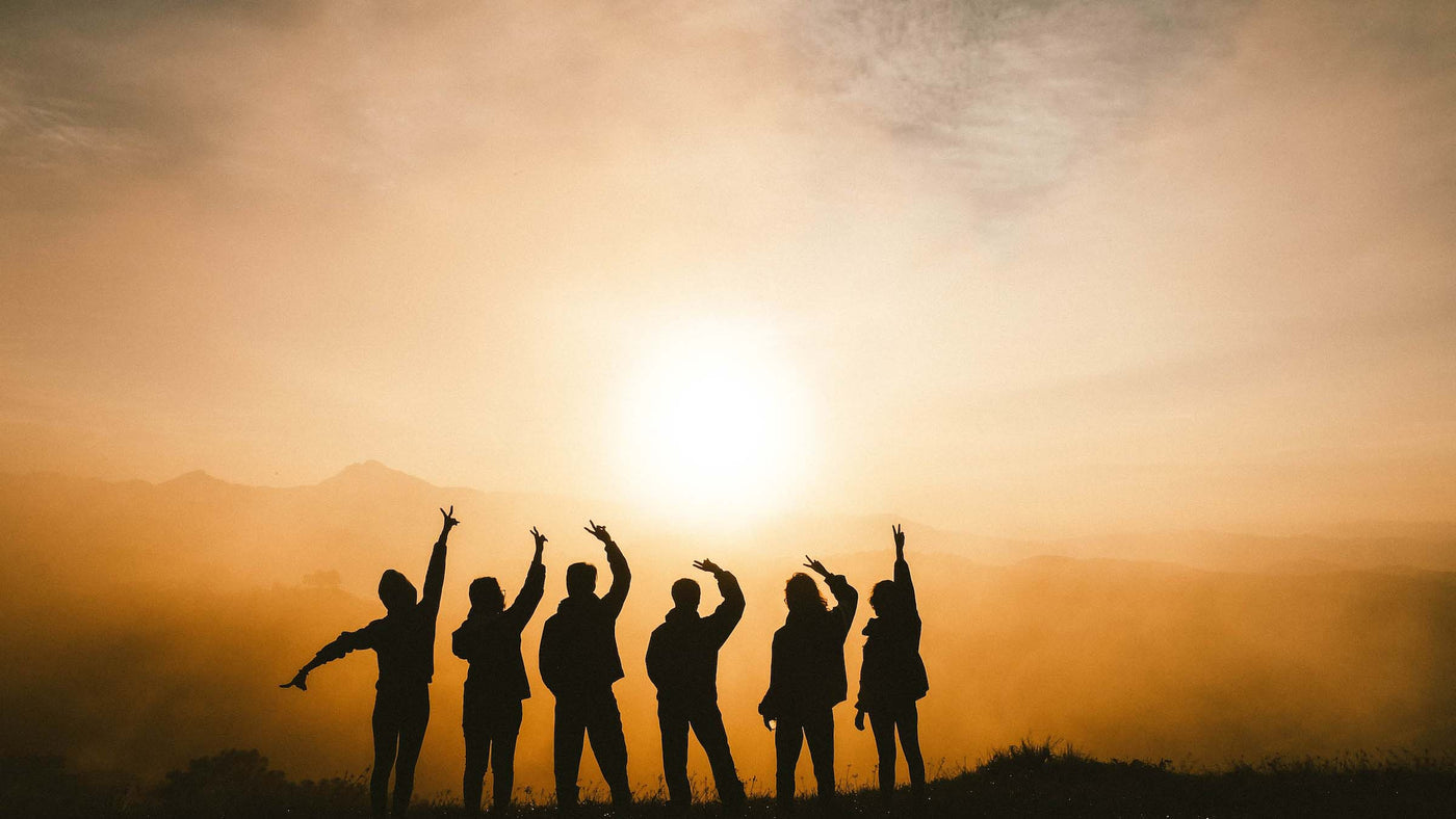 silhouette of a group of people admiring a sunrise