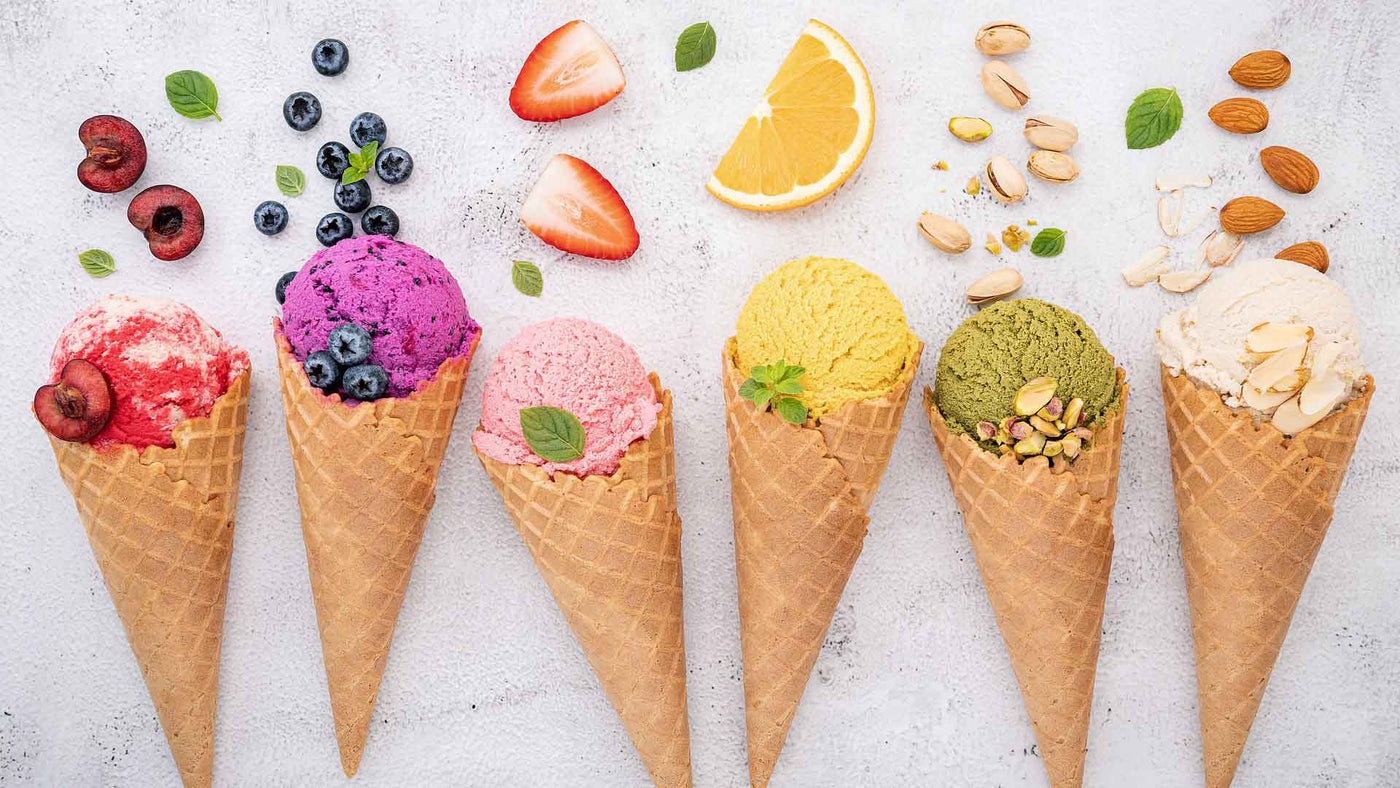 six ice cream cones with fruit, nuts, and mint leaves