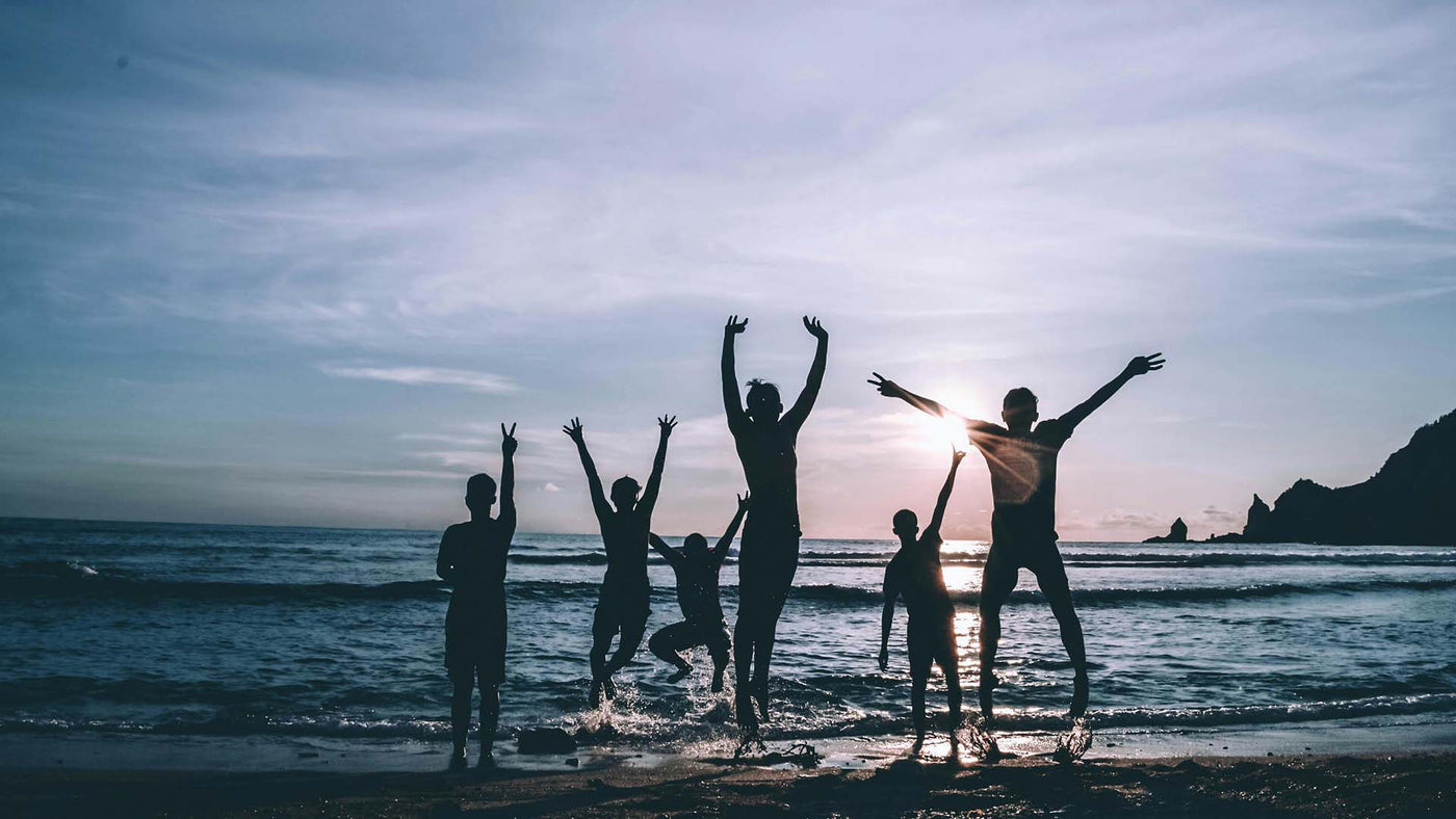 Silhouette of six people joyfully leaping on a beach