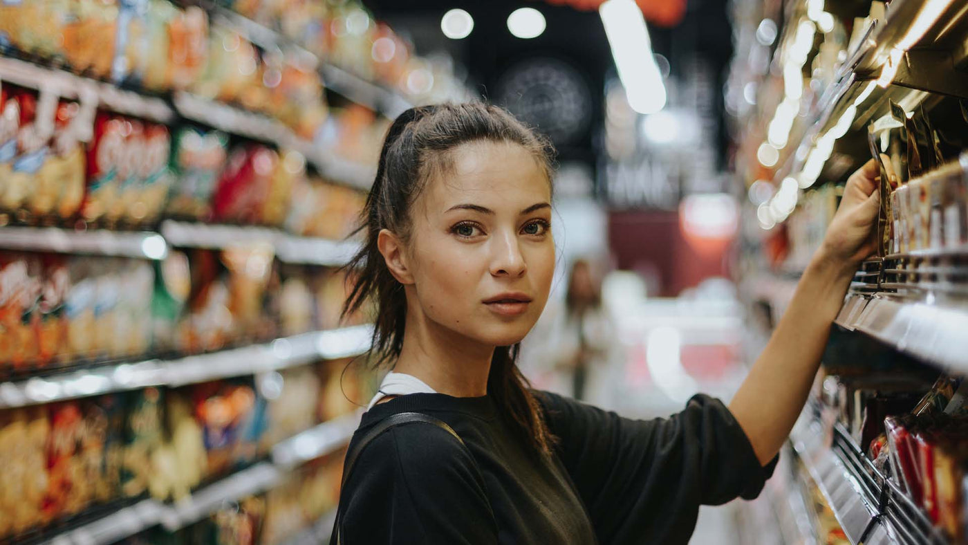 woman getting a product in a store aisle