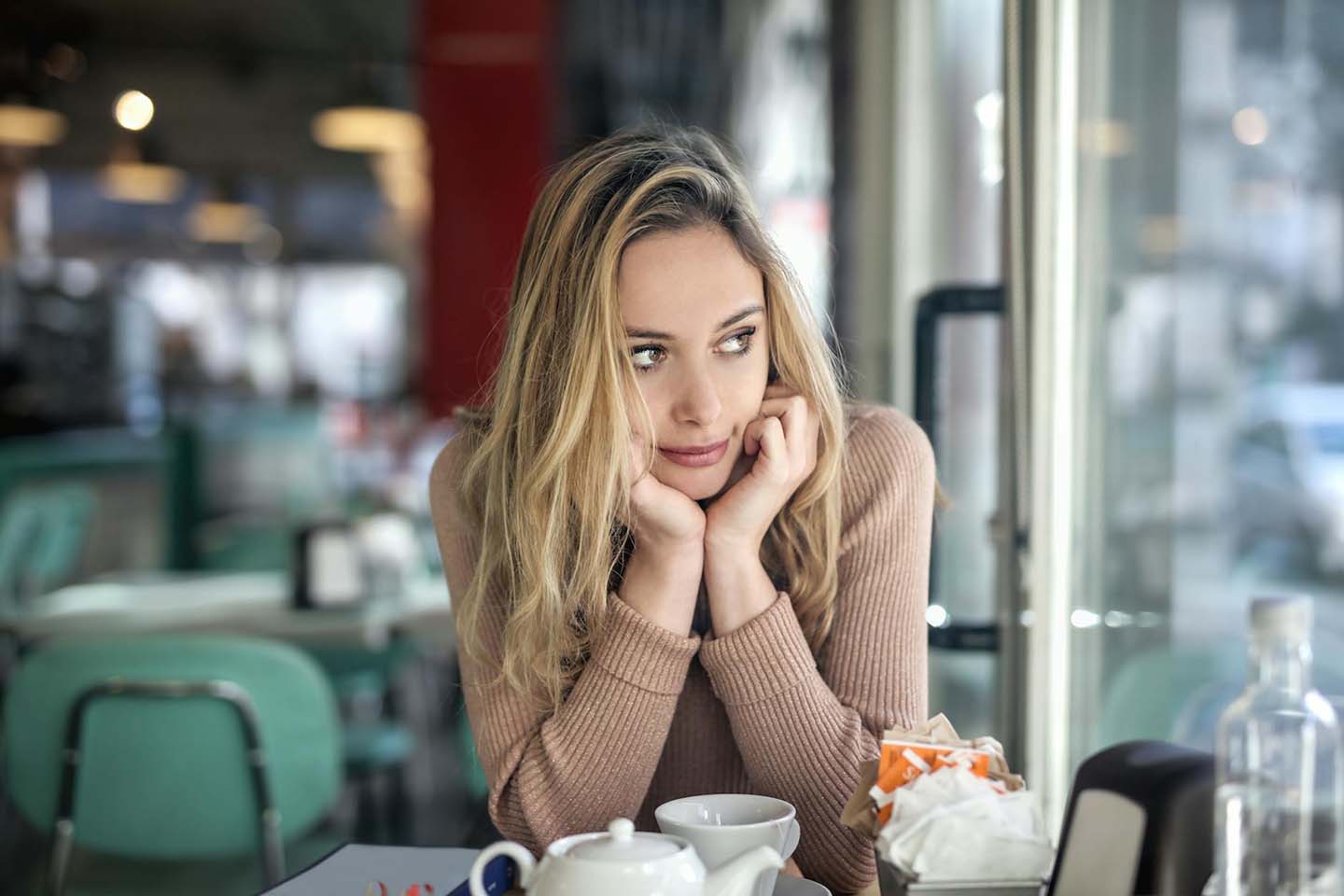 A woman sitting in a cafe and looking outside