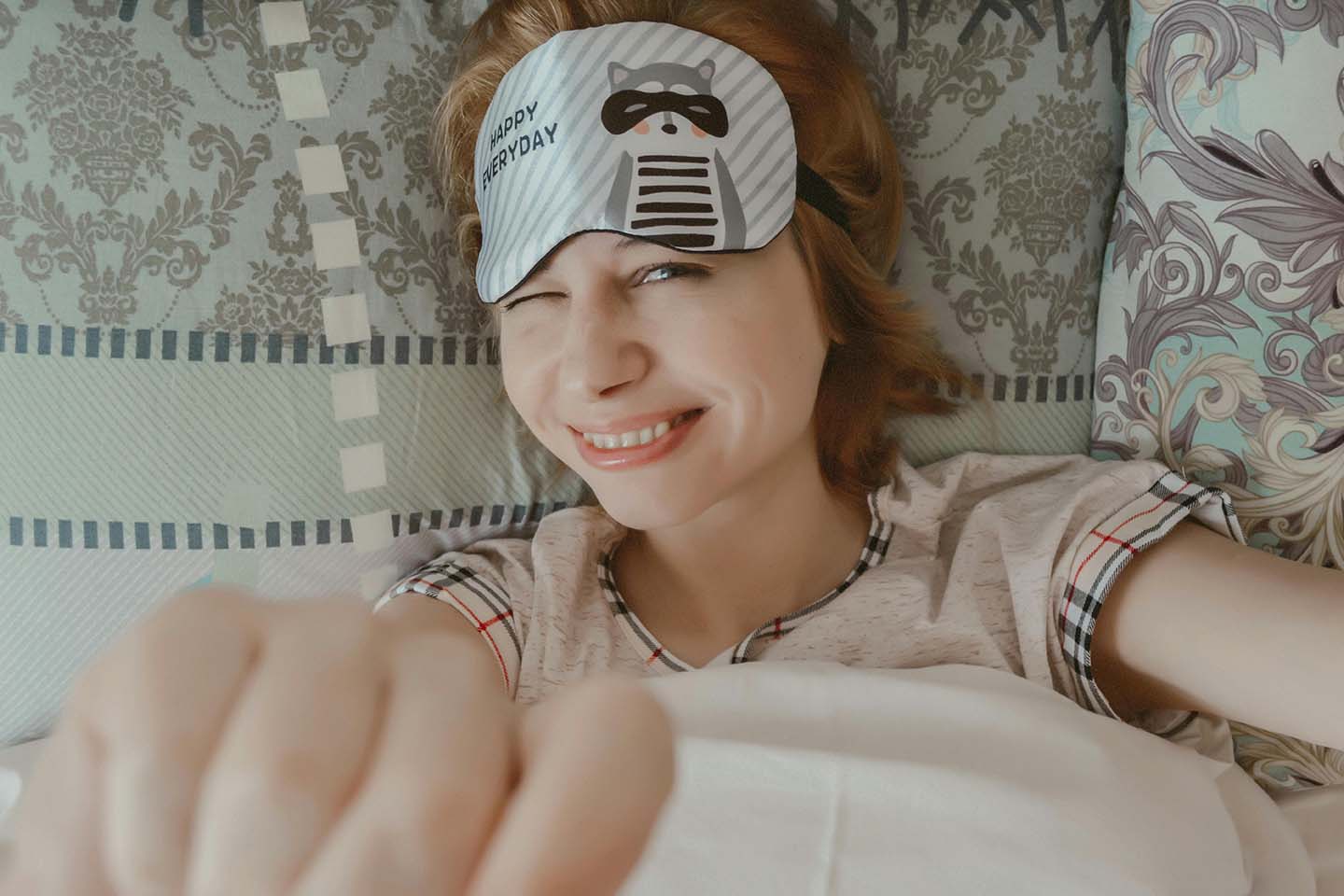 Smiling woman with sleep mask