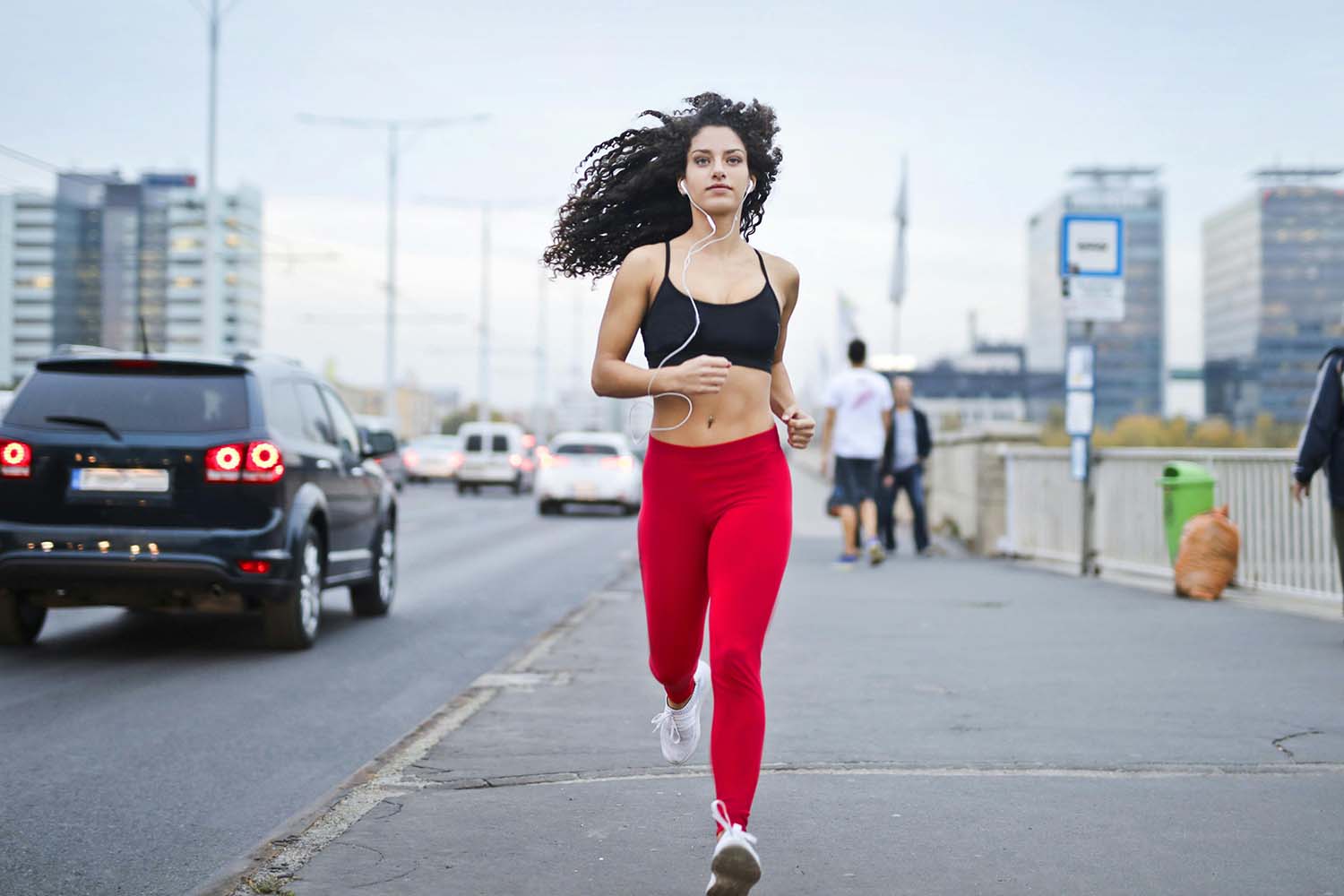 Woman running on a sidewalk, listening to music