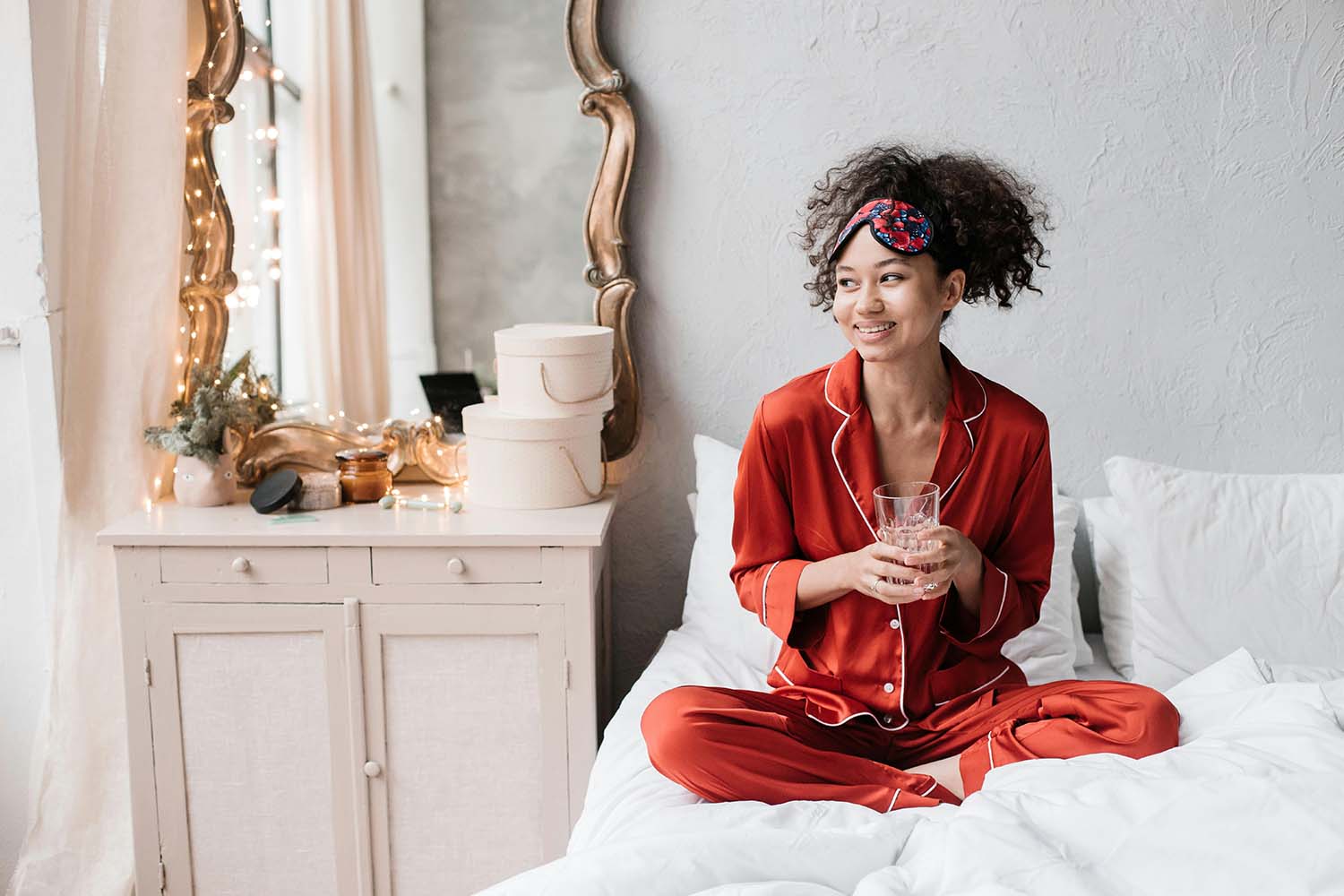 Woman sitting in bed holding a glass of water