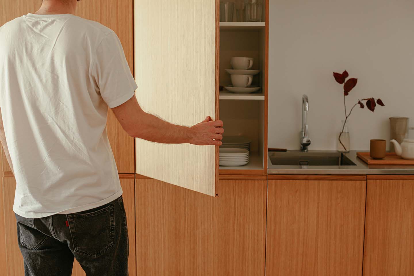 Person opening a kitchen cabinet