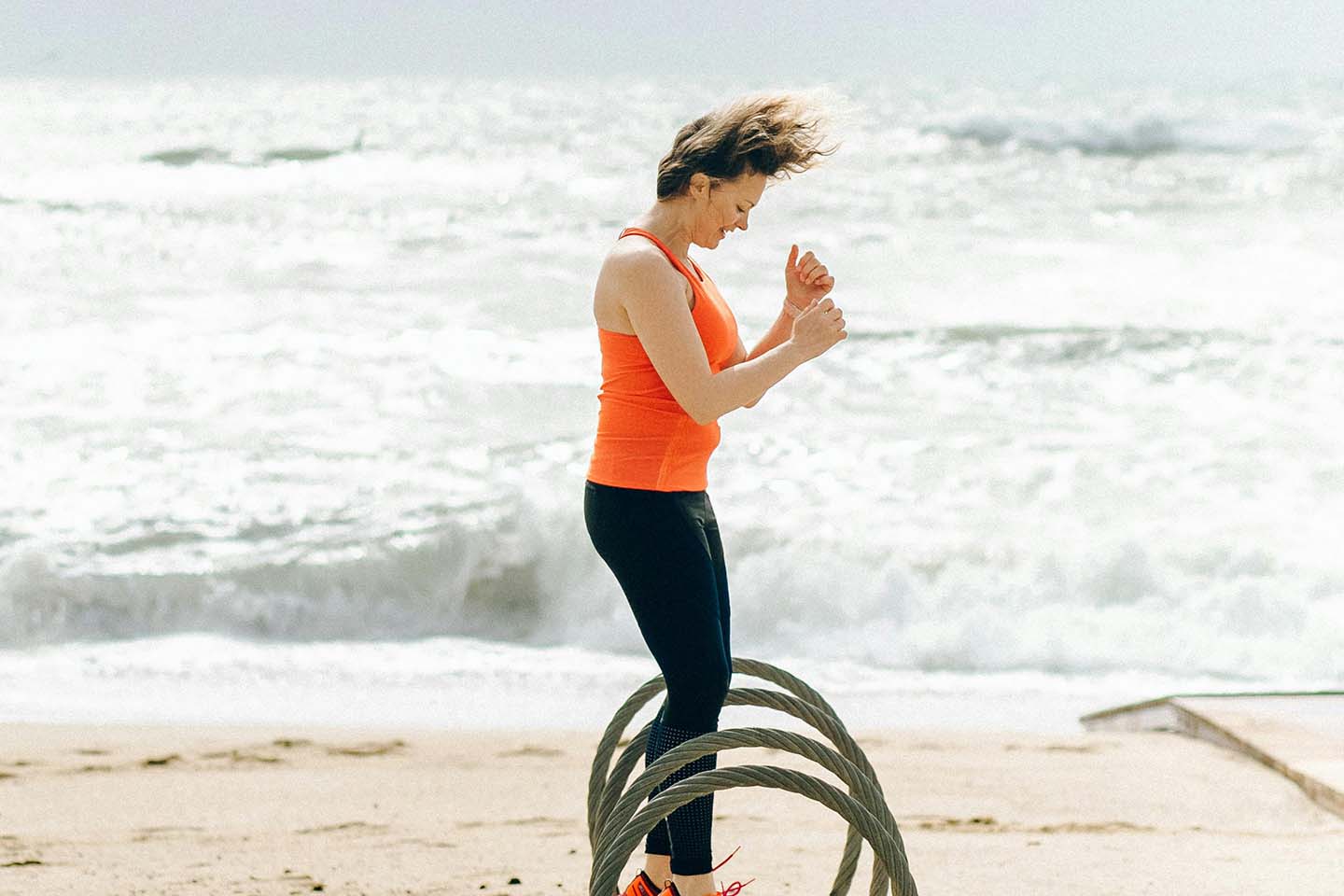 woman jumping and working out on the beach