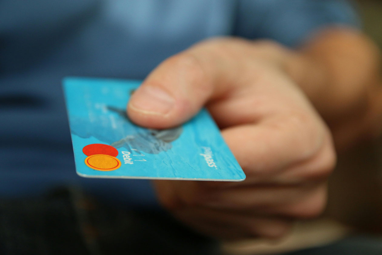 Person holding a blue credit card