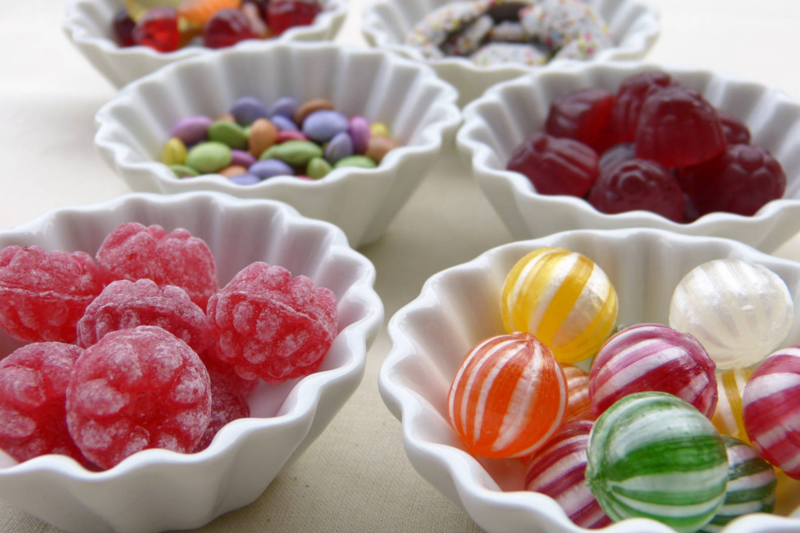 Assorted candies in white bowls