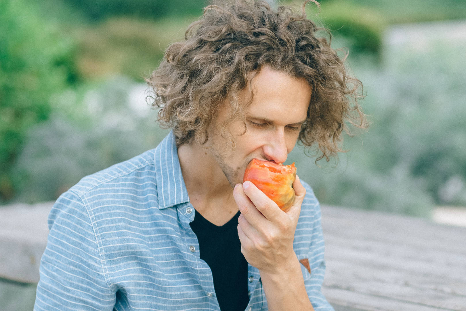 Man biting into a tomato