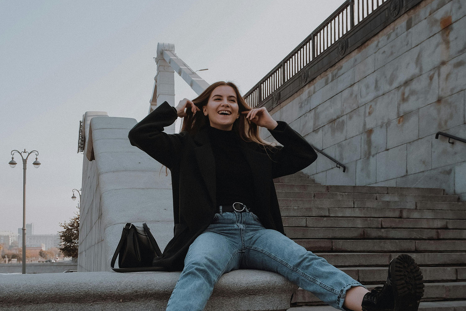 carefree woman sitting near stairs