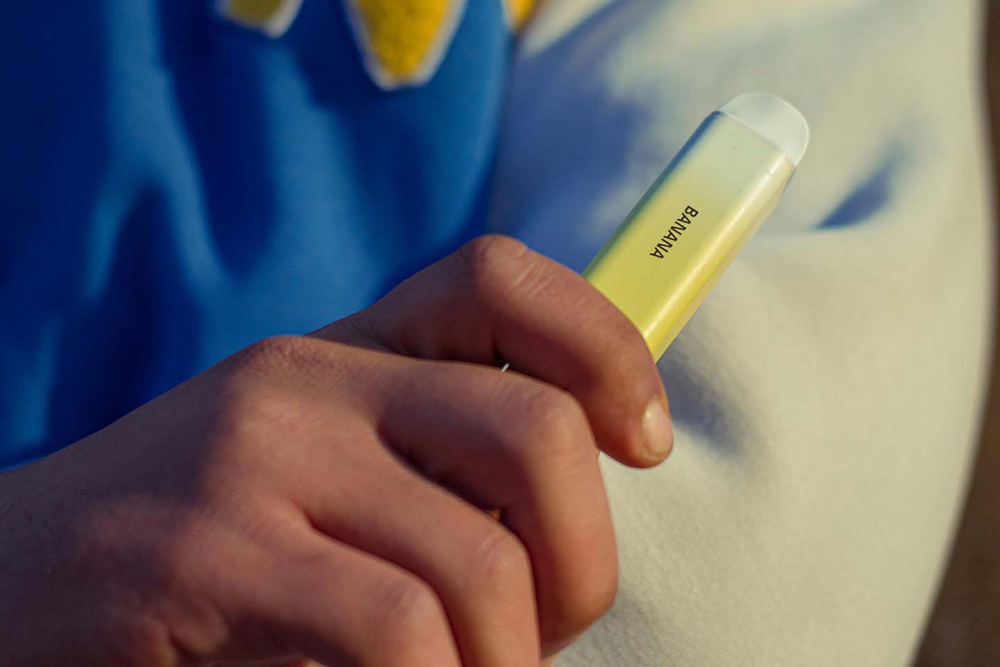 Closeup of person holding yellow vape