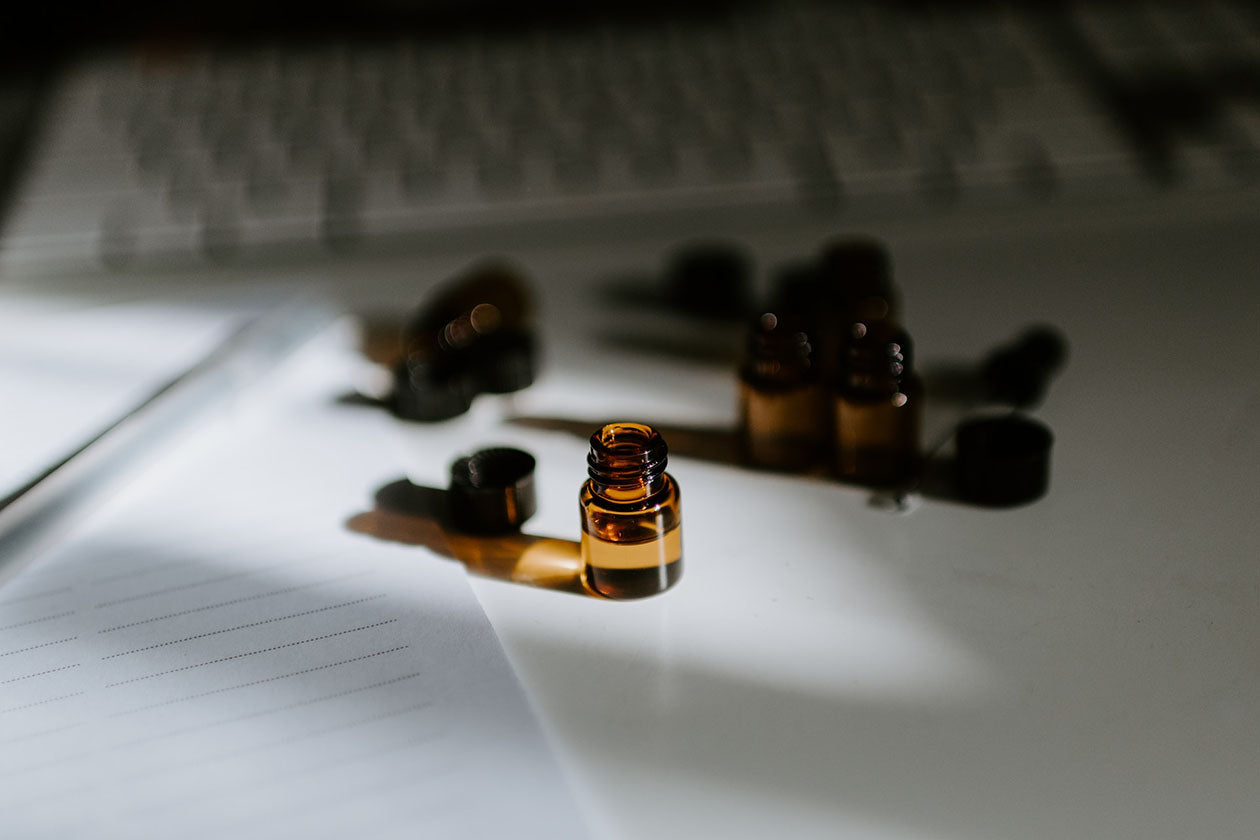small brown tinted glass bottles with oil on a desk