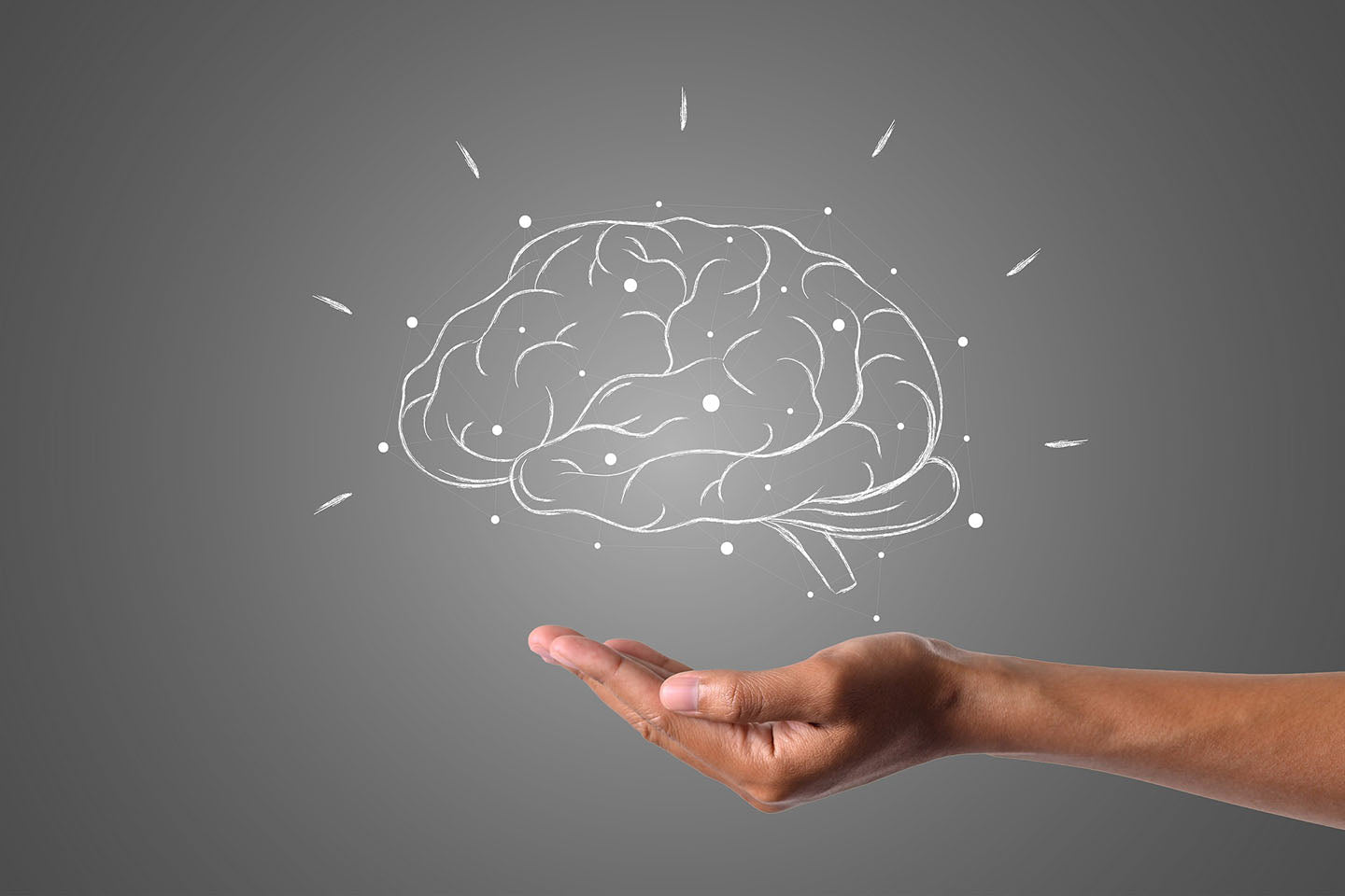 man's hand underneath a drawing of a brain
