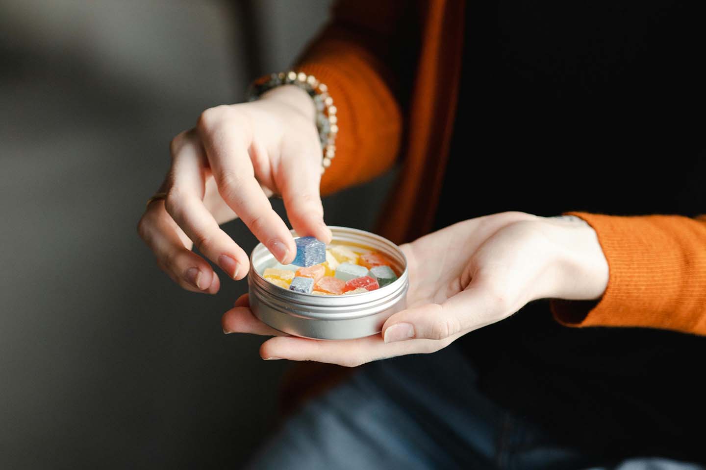 woman holding a tin of gummies