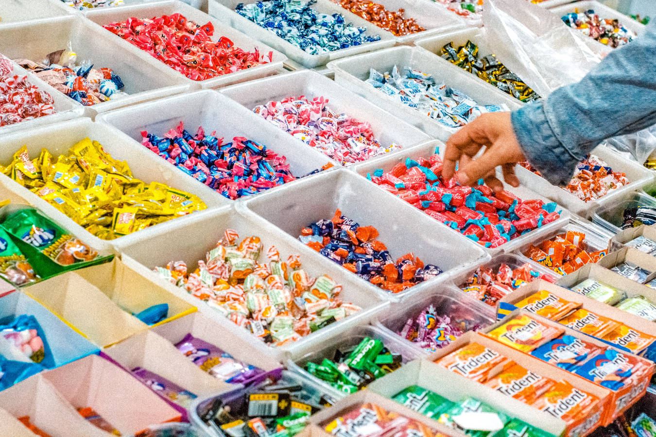 A person selecting a gum on a candy store.