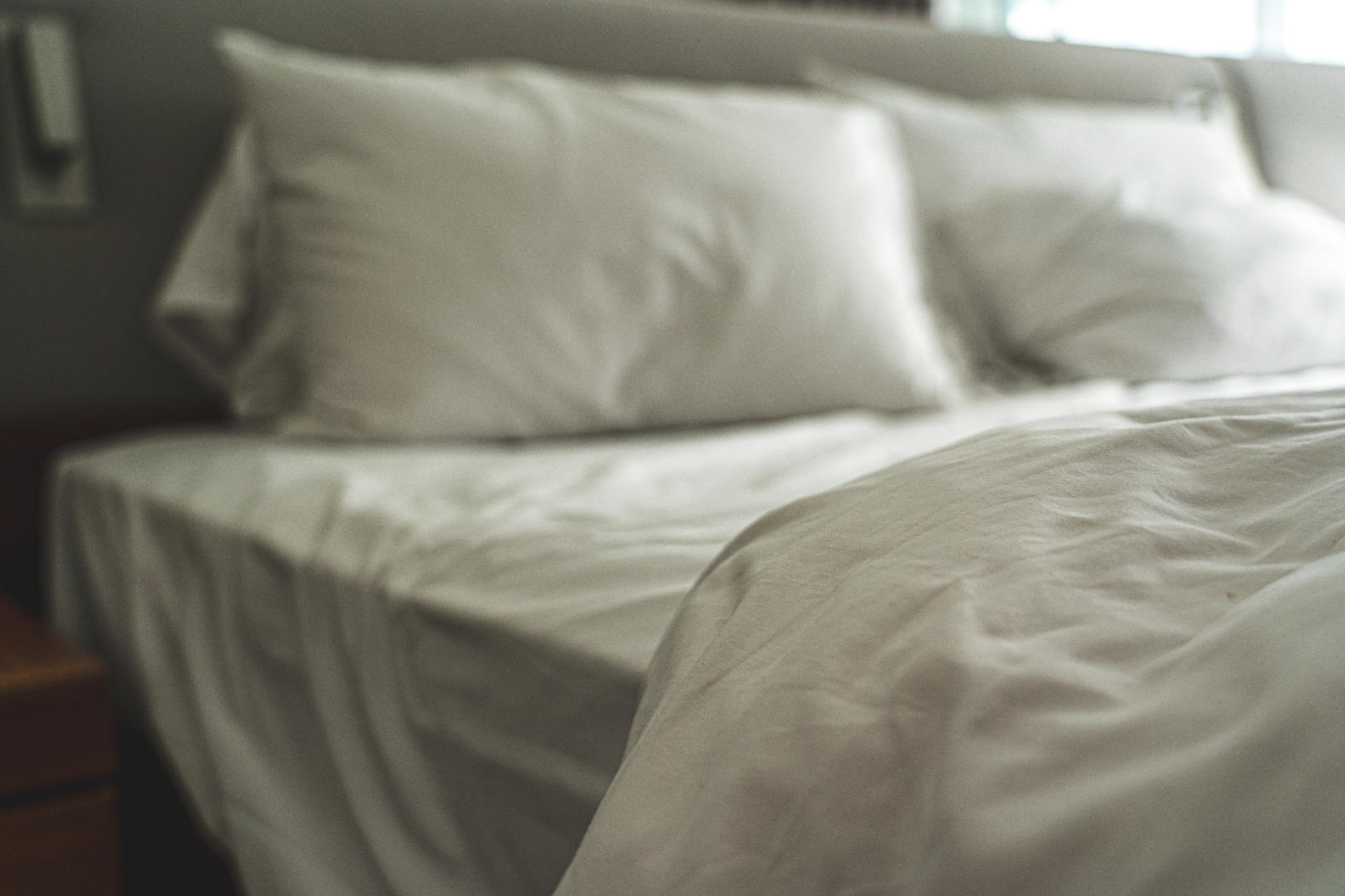 A cozy bed with white pillow and white sheets