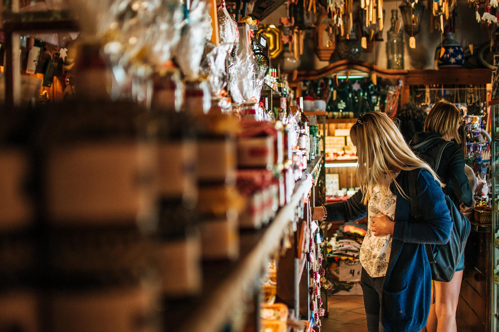 A woman picking a product from a store's shelf.