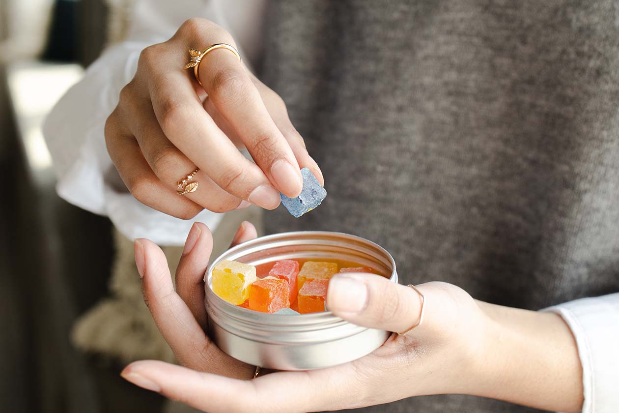 a person holding a can of gummy candy