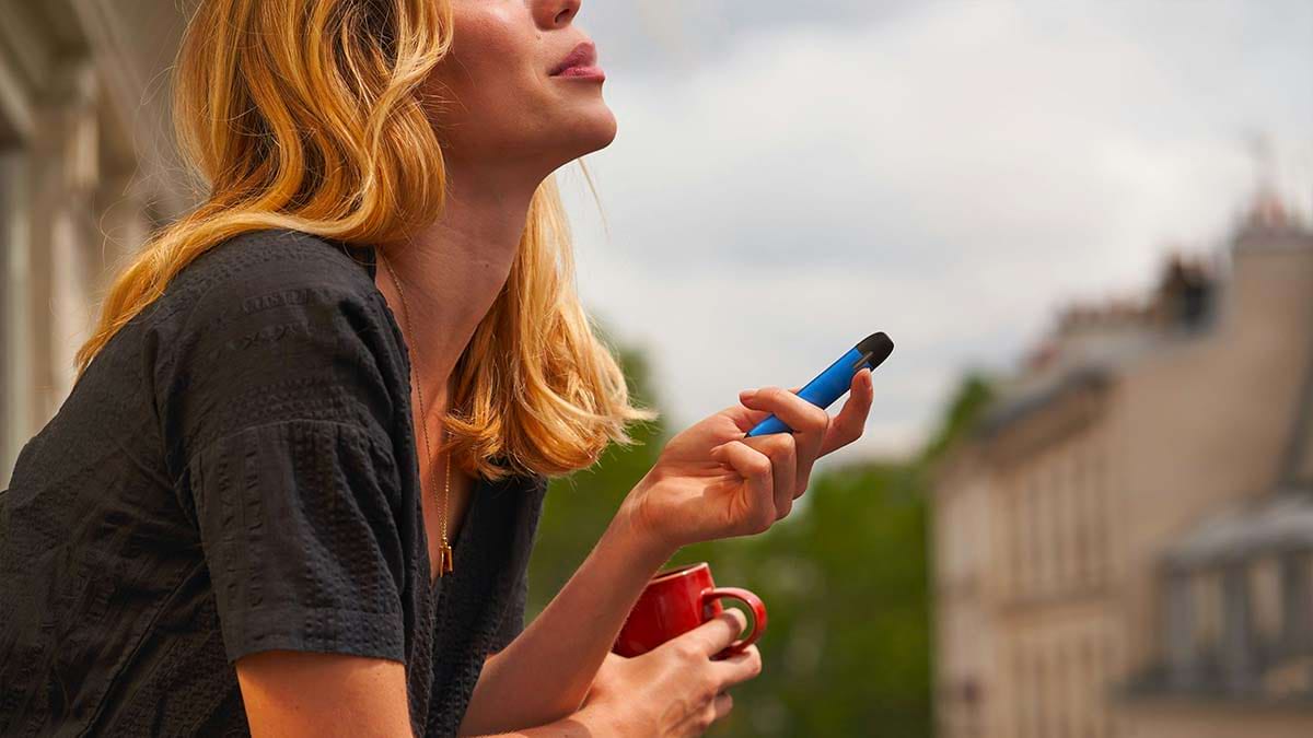 Young woman using a disposable vape.