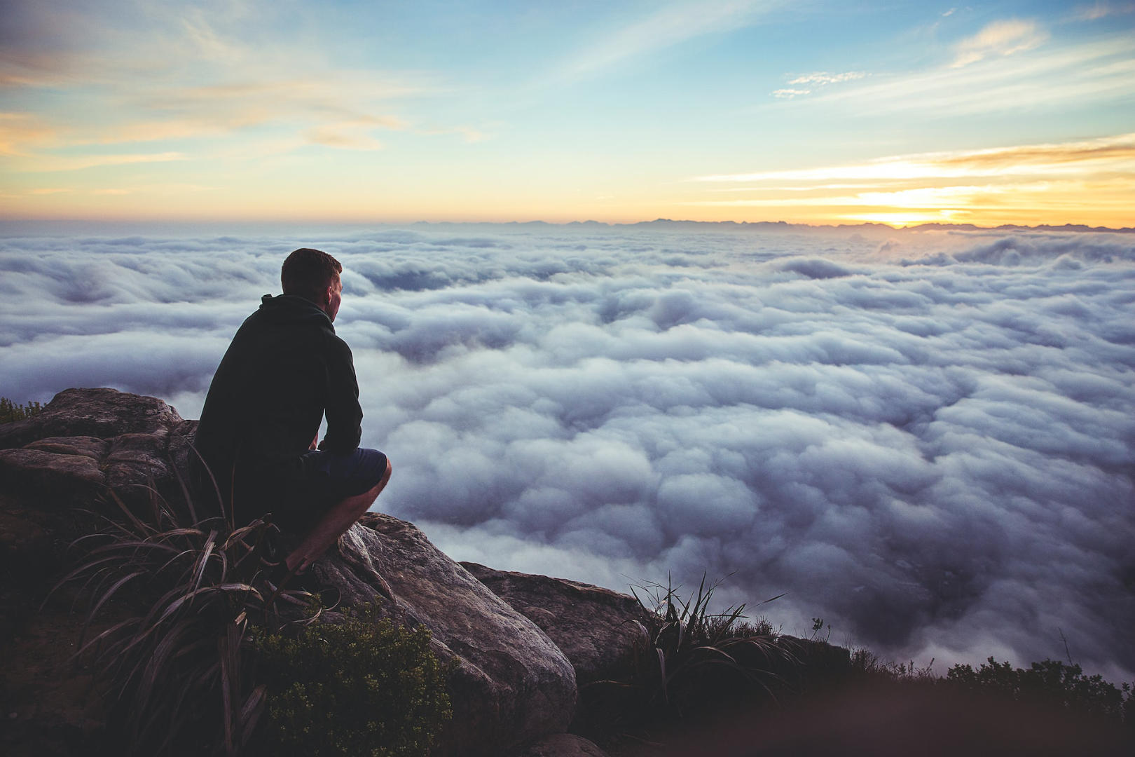 A man waiitng above the mountains looking at the sea of clouds.