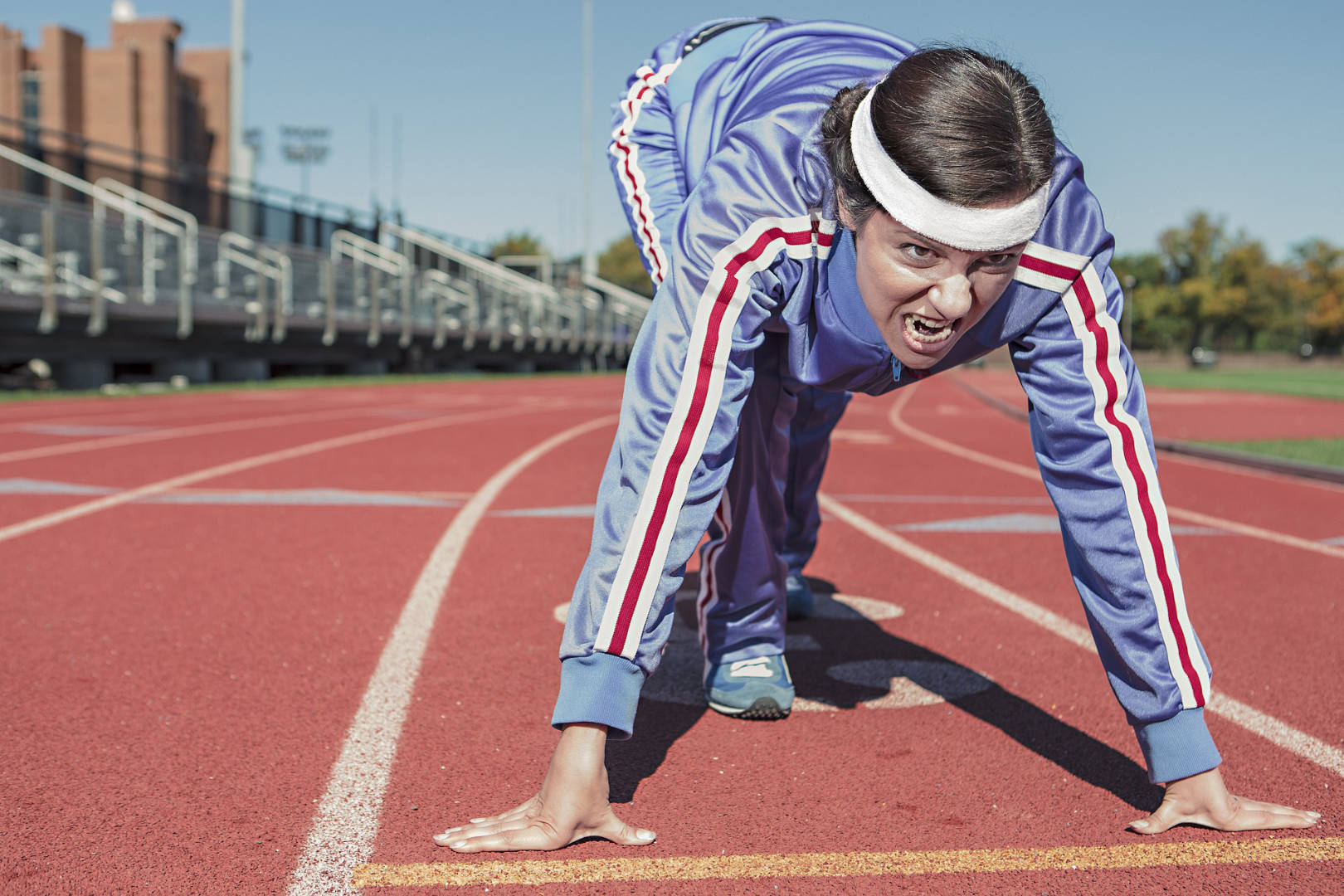 A woman athlete is about to run on the running track.