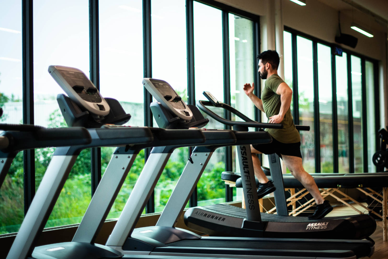 A man running on a treadmill in a gym.