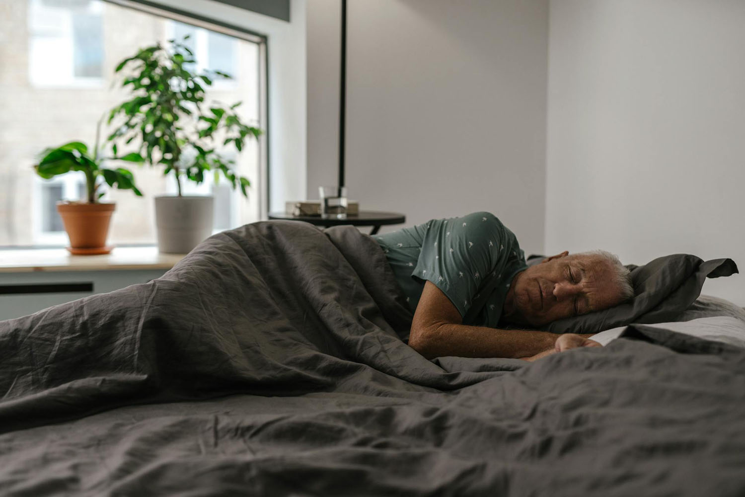 Older man sleeping in bed