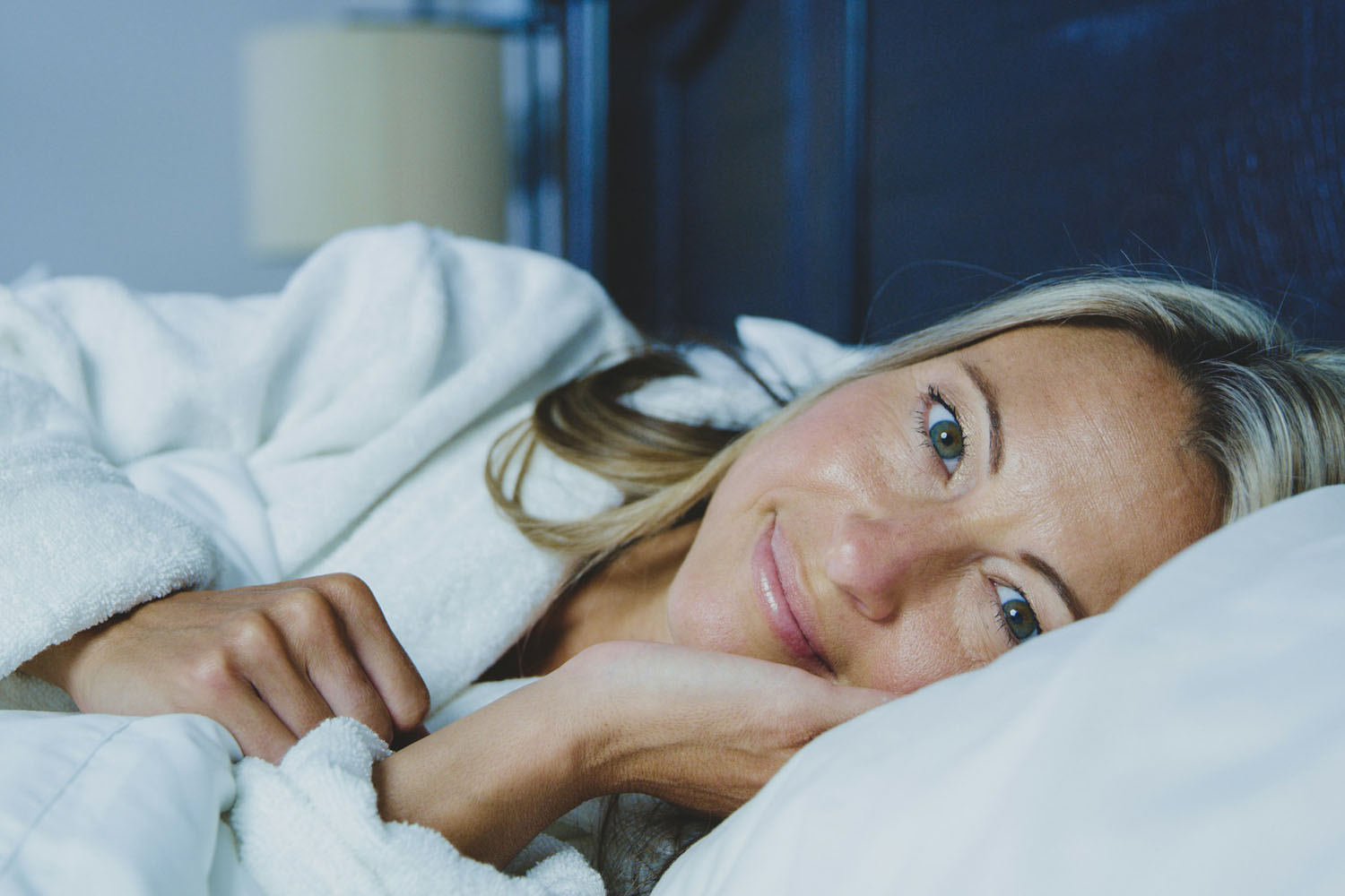 Smiling woman lying in bed