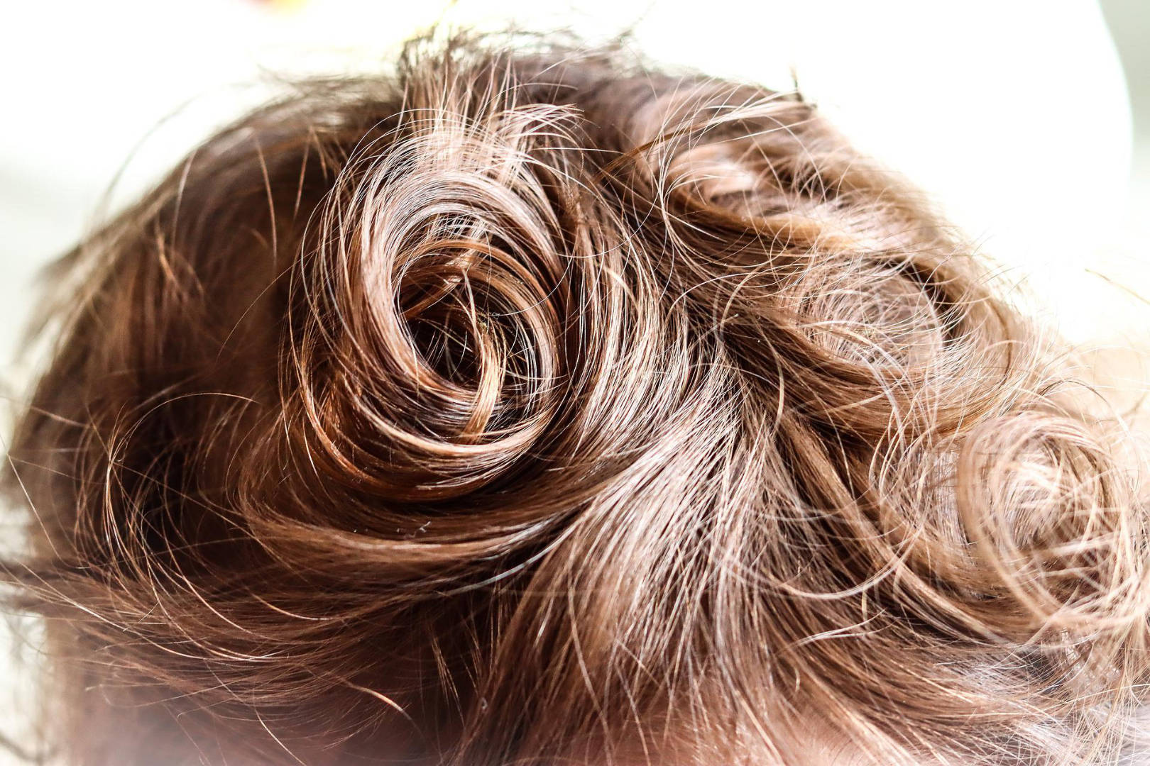 A close up shot of a gorgeous curly brown hair.