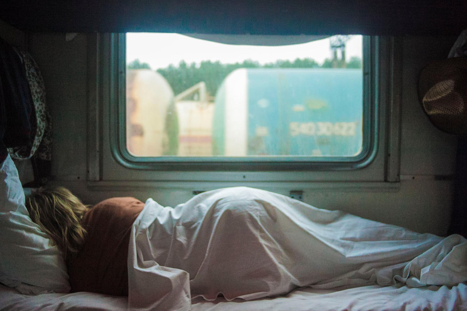 A woman sleeping on her side on a trailer.