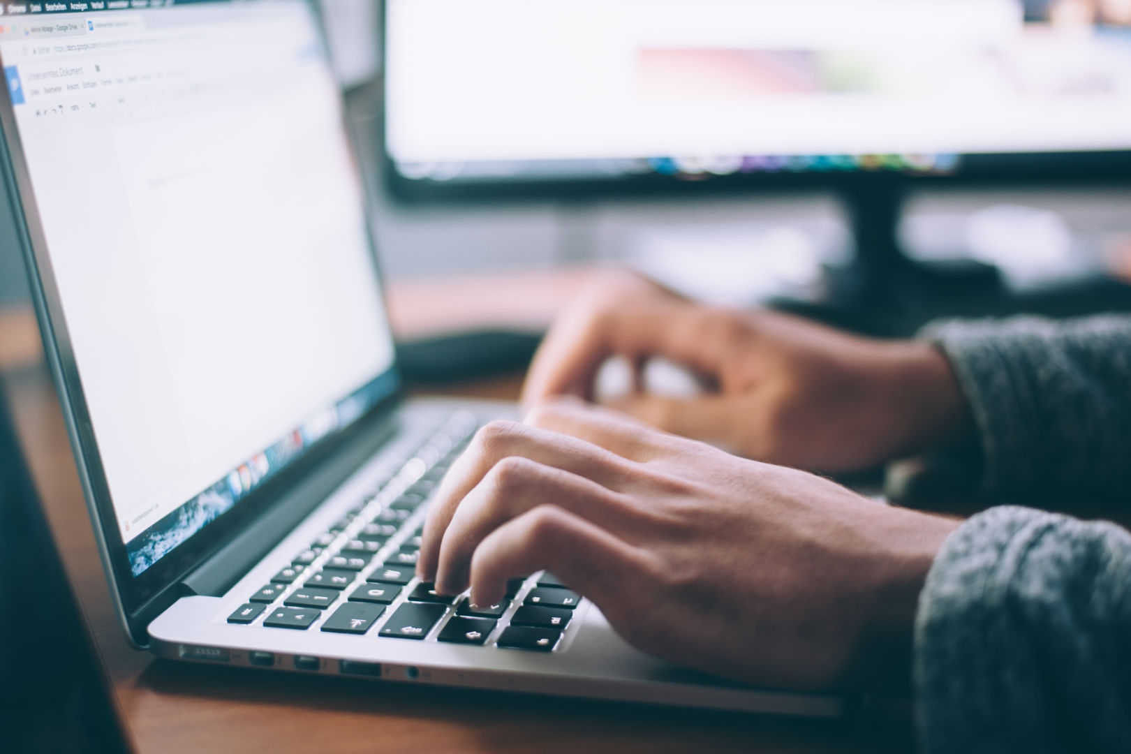person typing on a Macbook