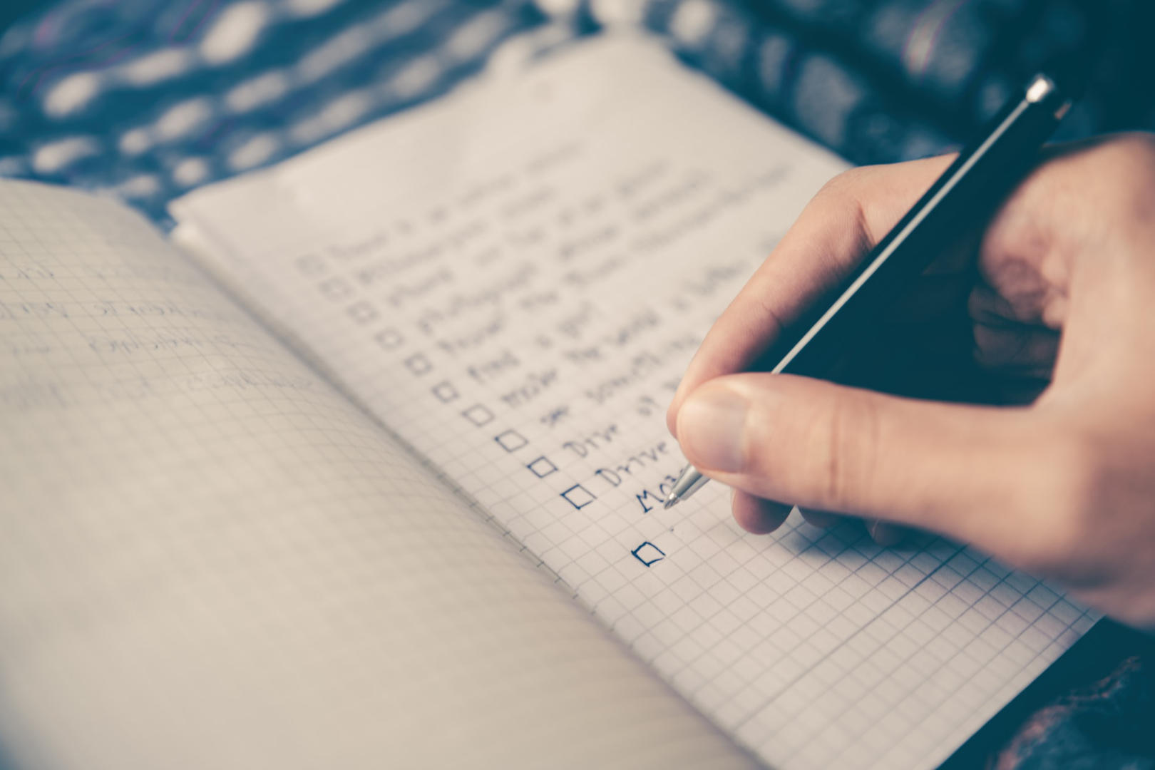 A person writing a list of tasks his planner.