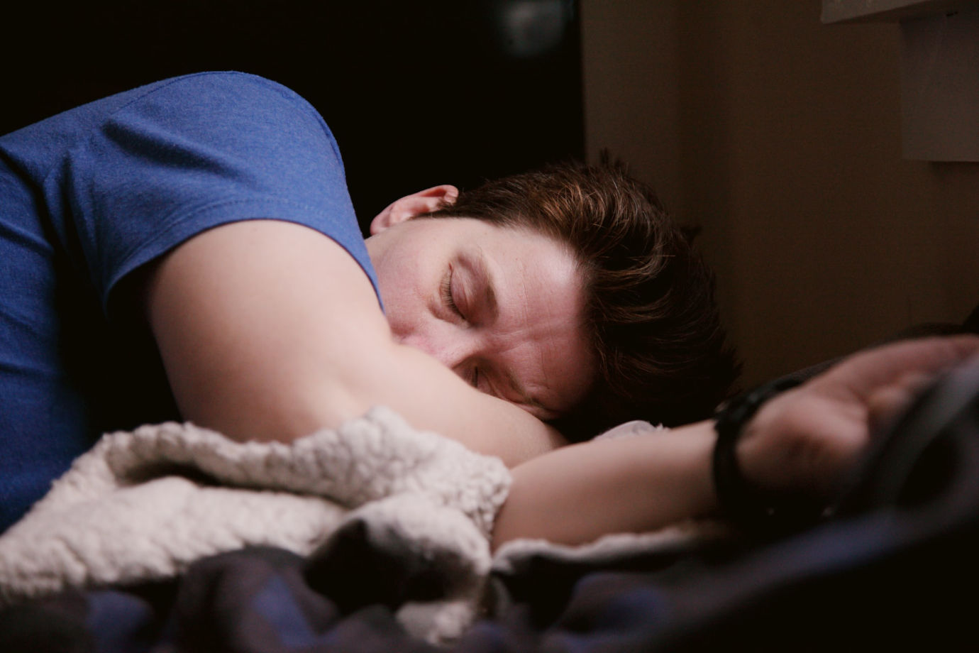 woman in blue shirt sleeping on bed