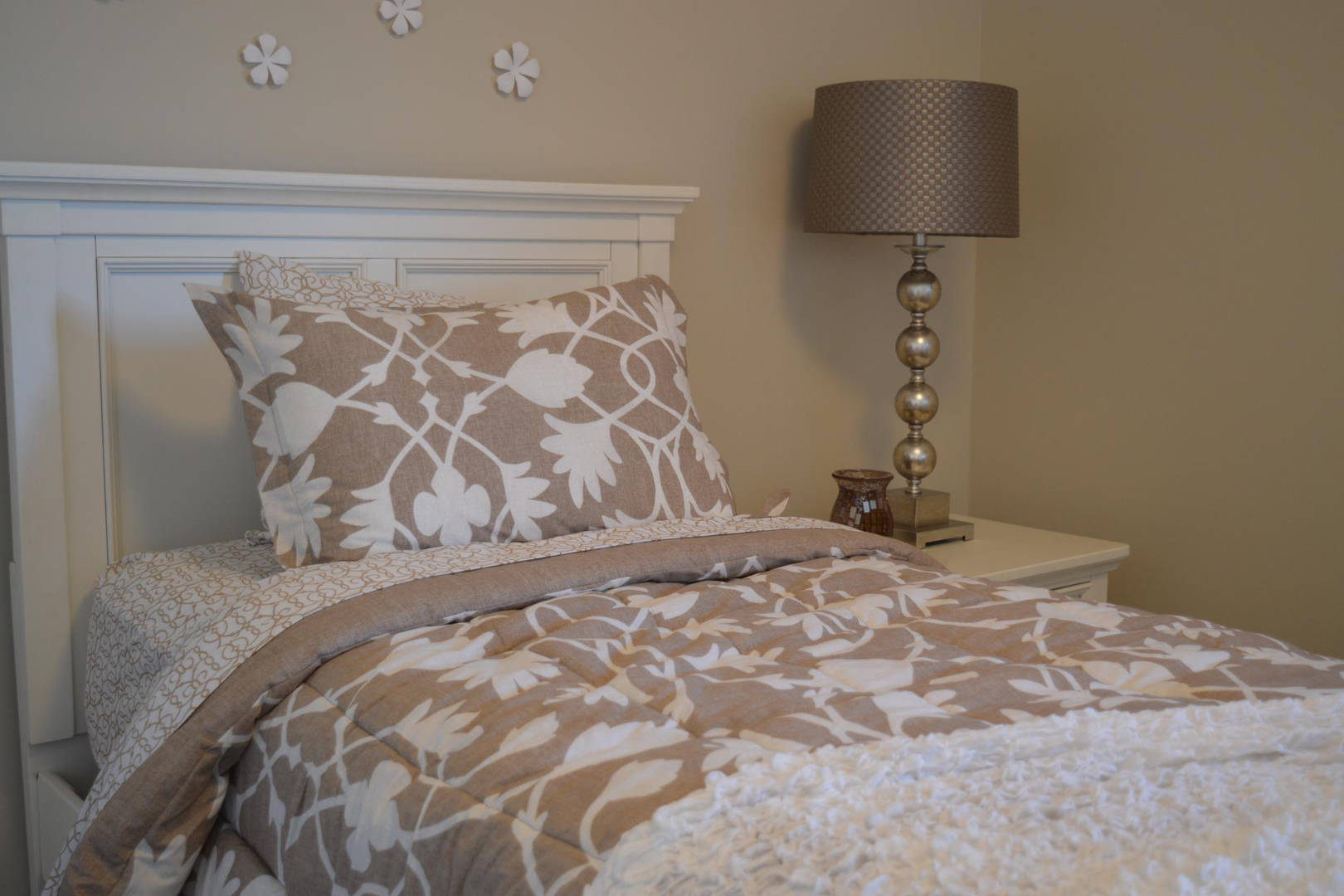 A bed with a lamp at the bedside table