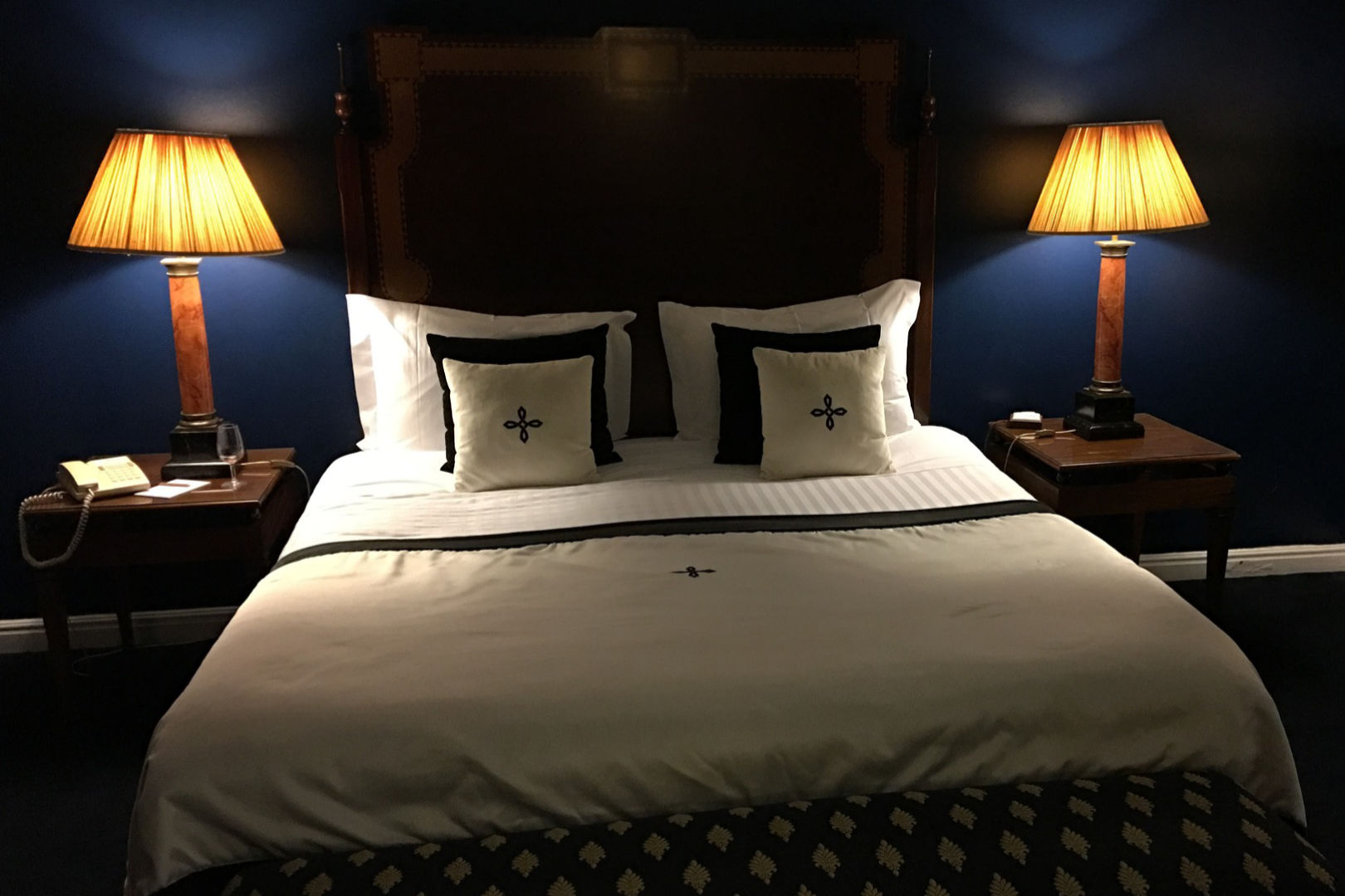 A bedroom with night lamps on each side of the bed.