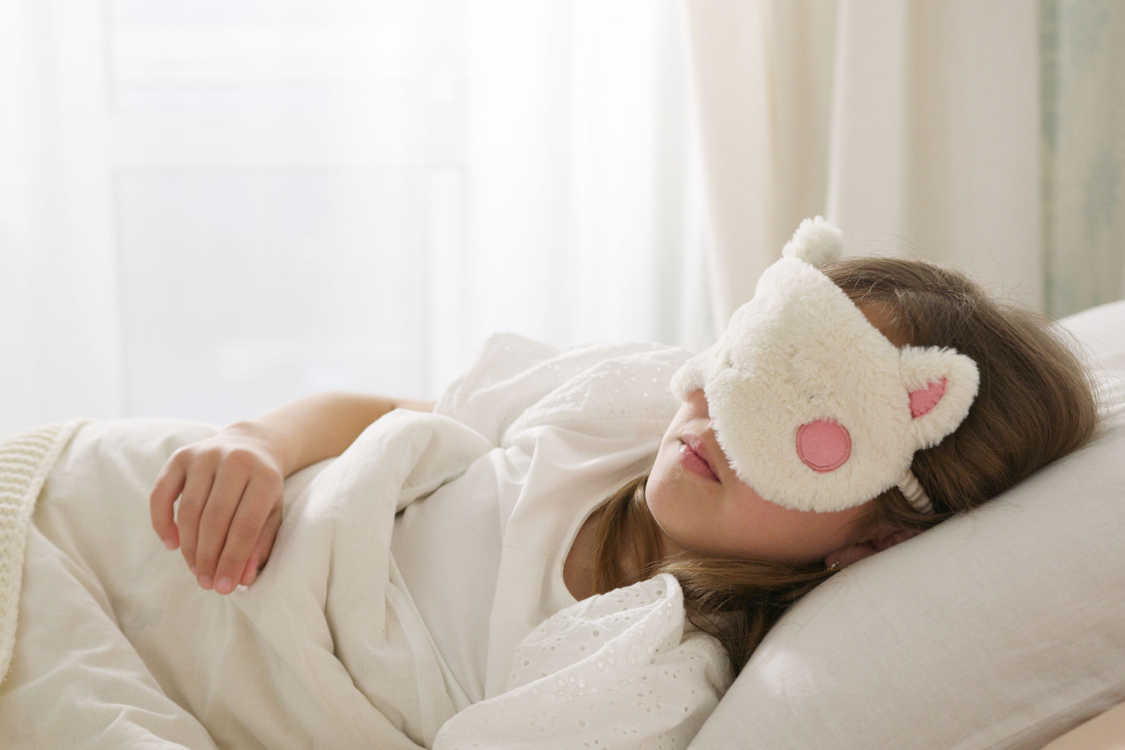 A girl sleeping with a cute eye mask on.