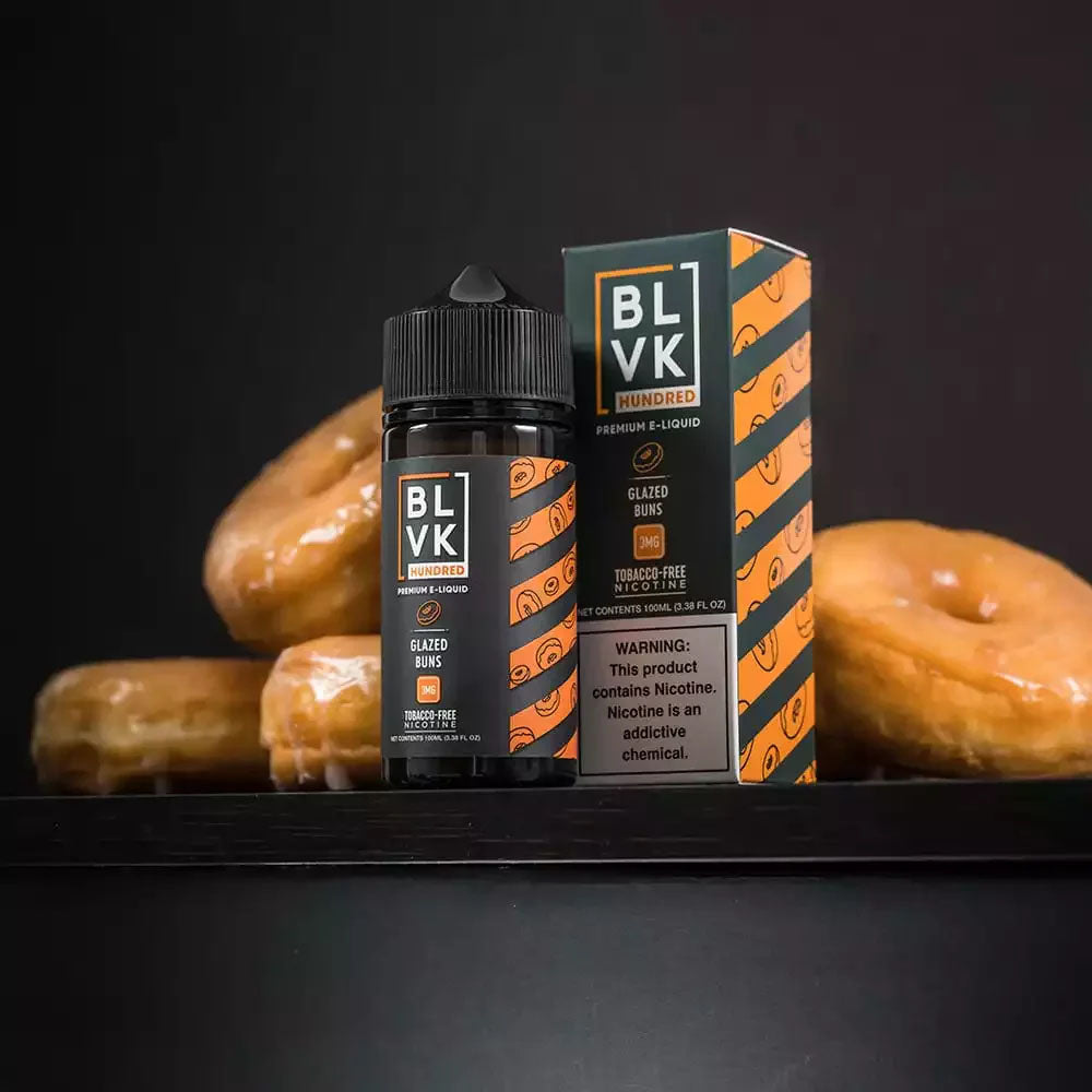 Bottle and box of BLVK Hundred's vape juice with glazed donuts